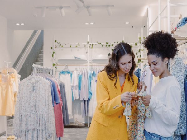 Two women browsing clothes in a stylish, modern boutique