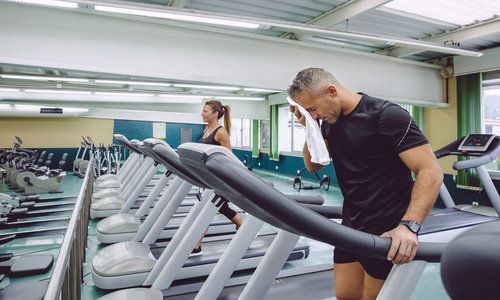 Man Drying with Towel over a Treadmill