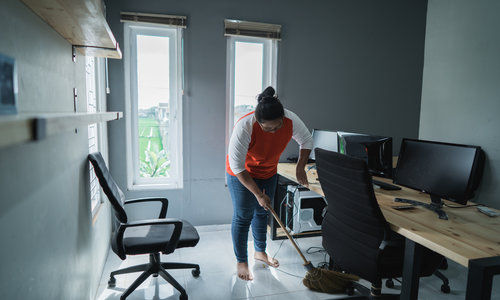 Young Woman Cleaning Floor In An Office.